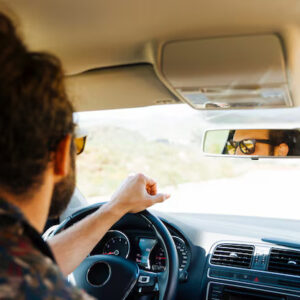 Man driving car with scenic road view.