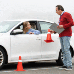Female student driver and instructor with traffic cones