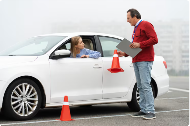 Female student driver and instructor with traffic cones