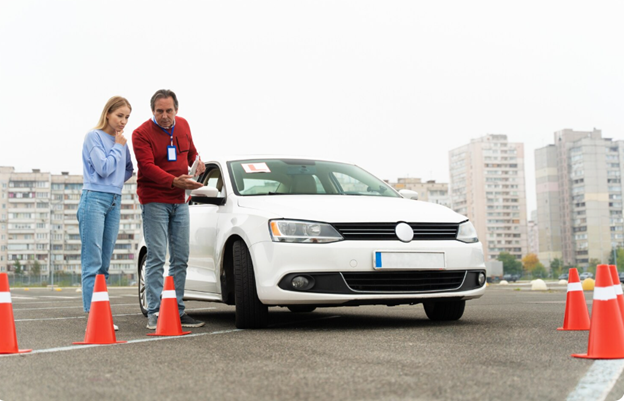 Instructor teaching student to drive white car.